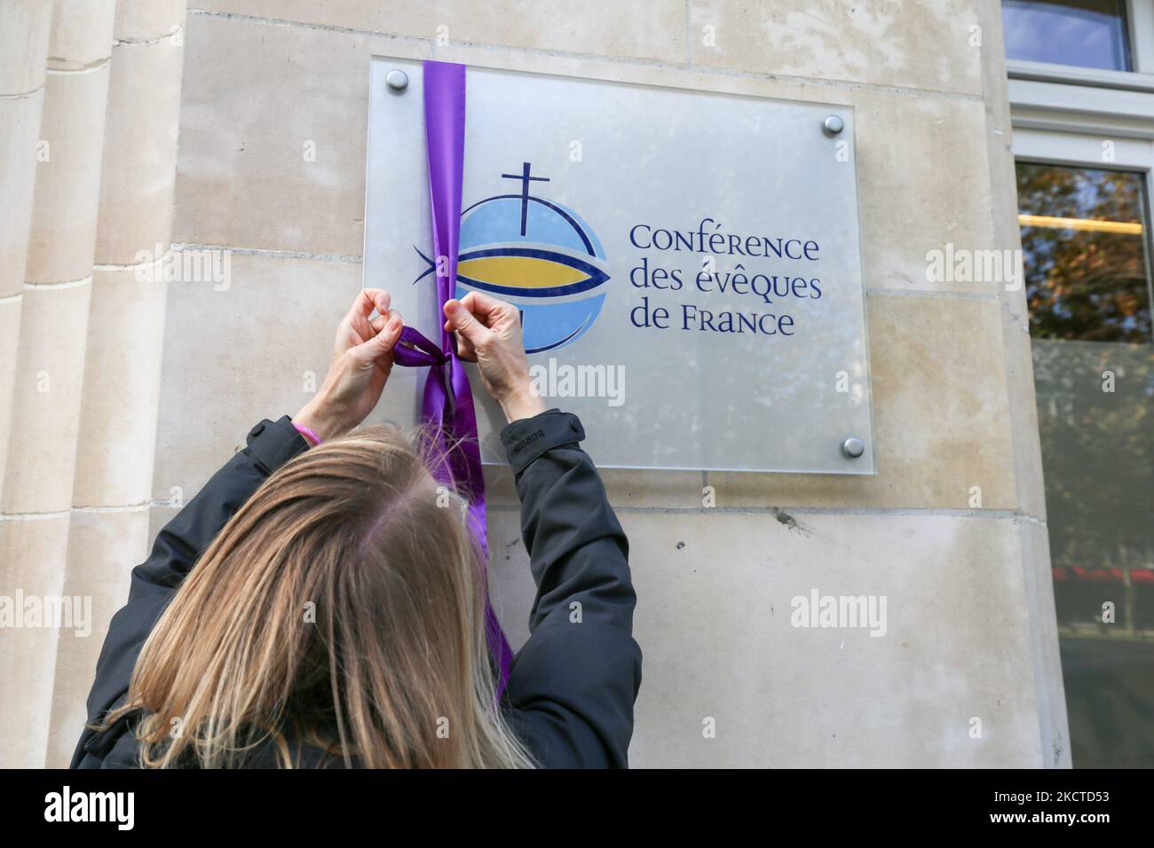 Les membres de l'association "de la libération conditionnelle aux actes" pendent un ruban violet, de la couleur de la robe traditionnelle des évêques de l'Église catholique, sur la plaque de construction du siège de la Conférence des Evêques de France (CEF - Conférence épiscopale française) à Paris, sur 6 novembre, 2021. La réunion annuelle des évêques a commencé à 2 novembre 2021 à Lourdes, où ils ont une semaine pour réfléchir au suivi à donner aux révélations du rapport Sauve, un mois après la publication d'un rapport dévastateur sur la violence sexuelle généralisée des enfants au sein de l'institution. (Photo de Michel Stoupa Banque D'Images