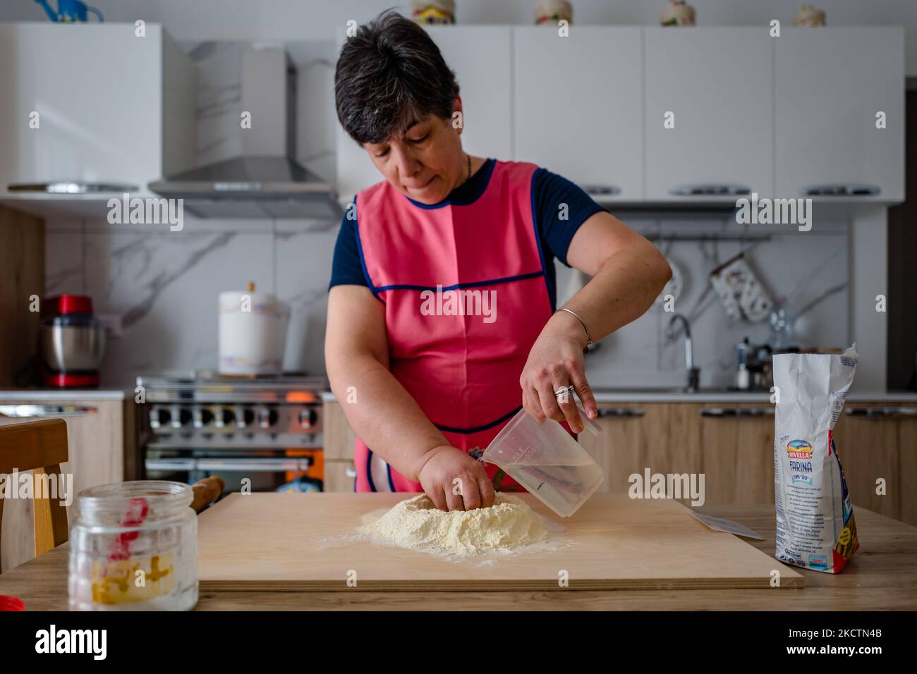ISA de Palma prépare le frittelle à la maison à l'occasion de San Martino le 11 novembre 2021 à Molfetta. À San Martino, un Molfetta, il est traditionnel de préparer des frittelle, une sorte de panzerotto farci. Déjà en début de matinée, les ruelles, les rues, les immeubles d'appartements, chaque coin de la ville, en bref, est envahi par cette odeur de nourriture authentique frite. La masse, déjà transformée et levain, est prête tôt le matin pour les garnitures de la célèbre et savoureuse frittelle de Molfetta des plus traditionnels avec mozzarella, oignon, thon et, surtout, la ricotta forte toutefois, moins et Banque D'Images