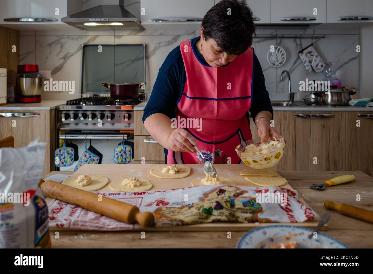 ISA de Palma prépare des frittelle maison à l'occasion de San Martino le 11 novembre 2021 à Molfetta. À San Martino, un Molfetta, il est traditionnel de préparer des frittelle, une sorte de panzerotto farci. Déjà en début de matinée, les ruelles, les rues, les immeubles d'appartements, chaque coin de la ville, en bref, est envahi par cette odeur de nourriture authentique frite. La masse, déjà transformée et levain, est prête tôt le matin pour les garnitures de la célèbre et savoureuse frittelle de Molfetta des plus traditionnels avec mozzarella, oignon, thon et, surtout, la ricotta forte toutefois, moins et Banque D'Images