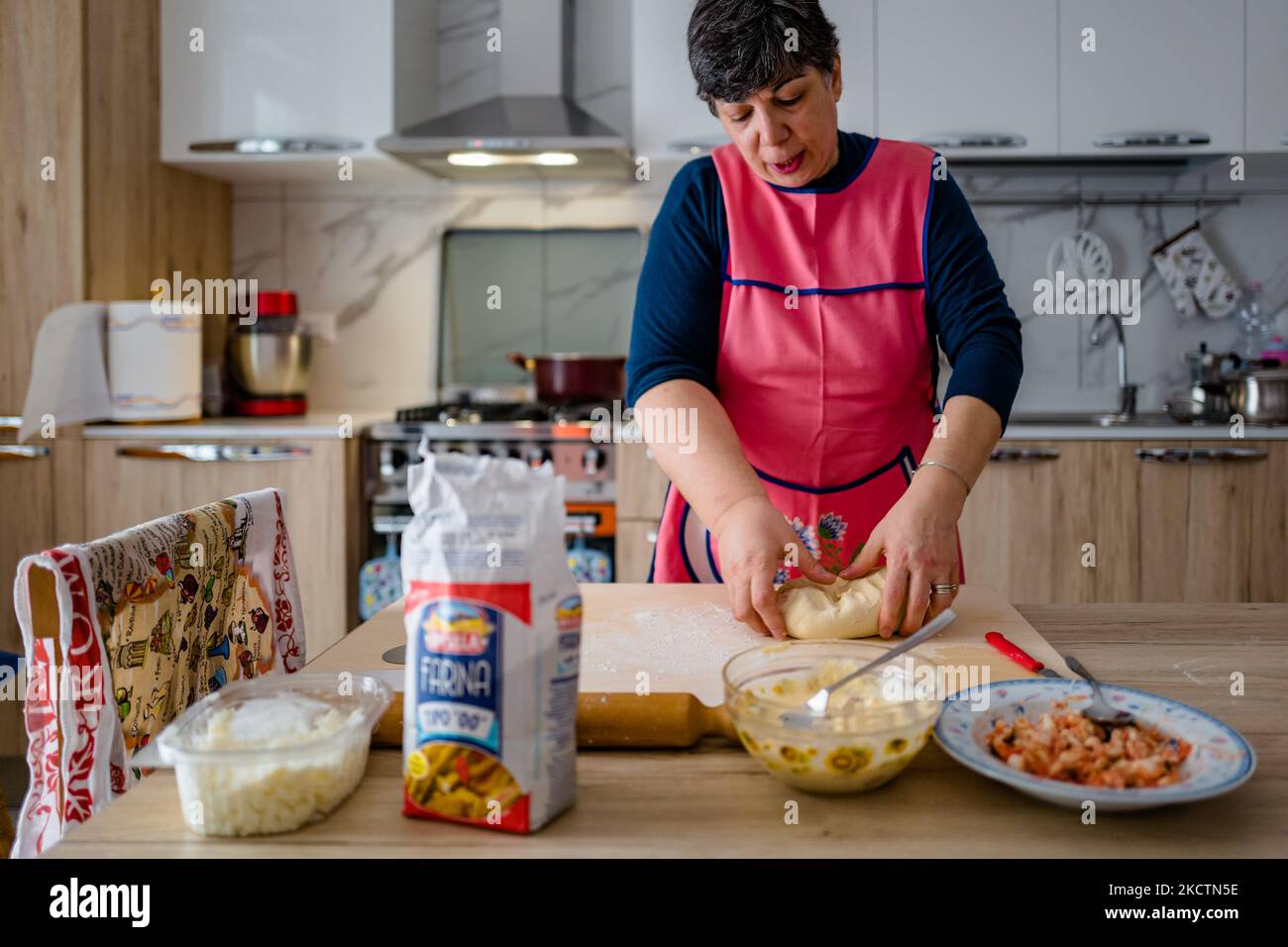 ISA de Palma prépare la messe pour la frittelle maison à l'occasion de San Martino le 11 novembre 2021 à Molfetta. À San Martino, un Molfetta, il est traditionnel de préparer des frittelle, une sorte de panzerotto farci. Déjà en début de matinée, les ruelles, les rues, les immeubles d'appartements, chaque coin de la ville, en bref, est envahi par cette odeur de nourriture authentique frite. La masse, déjà transformée et levain, est prête tôt le matin pour les remplissages de la célèbre et savoureuse frittelle de Molfetta des plus traditionnels avec mozzarella, oignon, thon et, surtout, forte ricotta H Banque D'Images