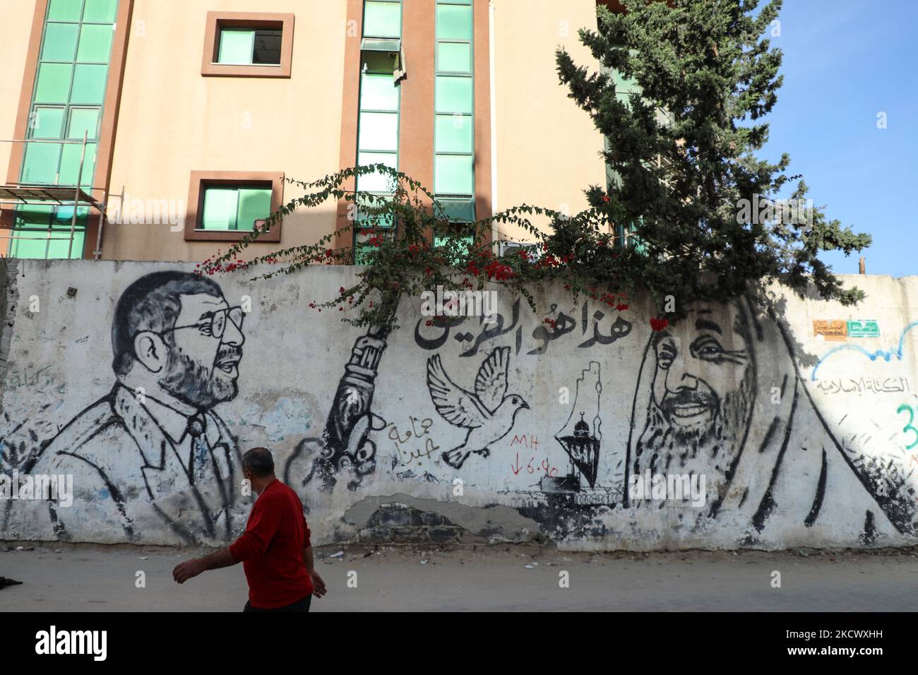 Un homme palestinien passe devant la graffitis de feu dirigeants du Hamas, Sheikh Ahmed Yassin (R) et Dr. Abdel Aziz Al-Rantisi (L), à Gaza, le 29 novembre 2021. Le ministre de l'intérieur britannique, Priti Patel, a pris la décision d'interdire le mouvement du Hamas, en le déclarant "organisation terroriste". (Photo de Majdi Fathi/NurPhoto) Banque D'Images