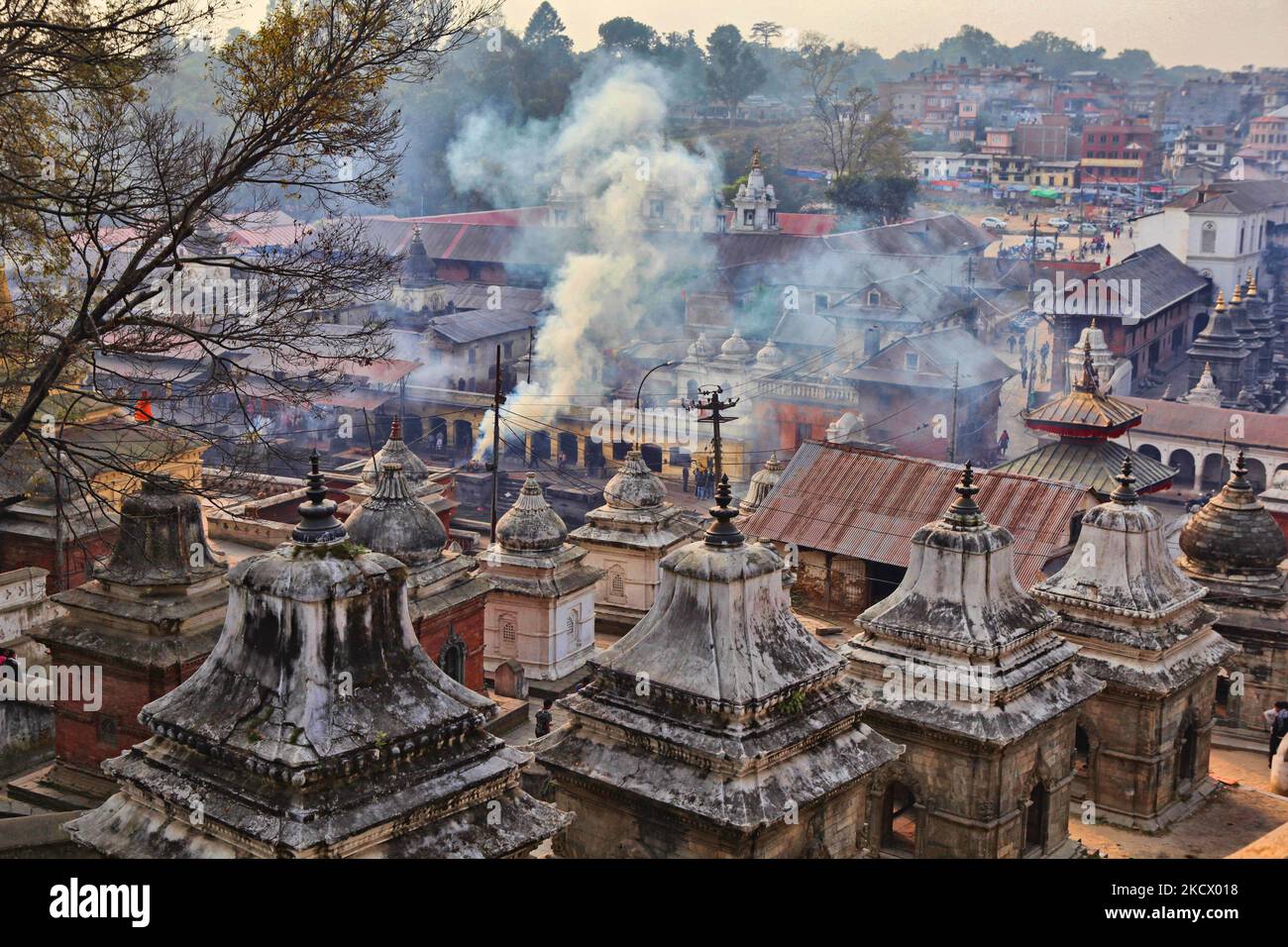 Fumée provenant d'un corps incinéré, vue parmi les nombreuses chayas et autres bâtiments du complexe du temple hindou de Pashupatinath, au Népal. En arrière-plan, la fumée s'élève des ghats de crémation, car un corps est incinéré par la rive de la rivière Bagmati. Le complexe de Pashupatinath est le plus sacré site hindou du Népal. (Photo de Creative Touch Imaging Ltd./NurPhoto) Banque D'Images