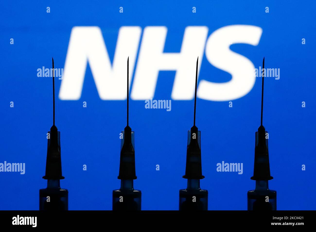 Les seringues médicales et le logo NHS affichés en arrière-plan sont illustrés sur cette photo prise à Cracovie, en Pologne, sur 2 décembre 2021. (Photo de Jakub Porzycki/NurPhoto) Banque D'Images