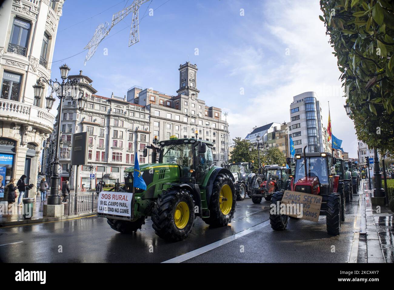 Tracteurs menant à la manifestation sur la rue Uría, le plus important dans la ville avec deux panneaux qui indiquent: «Vous êtes rural. Si la campagne pour la ville ne mange pas" et sur la droite: "Nous sommes un secteur primaire. Des prix intéressants '. Oviedo. Asturies. Espagne. Sur 2 décembre 2021. (Photo d'Alvaro Fuente/NurPhoto) Banque D'Images