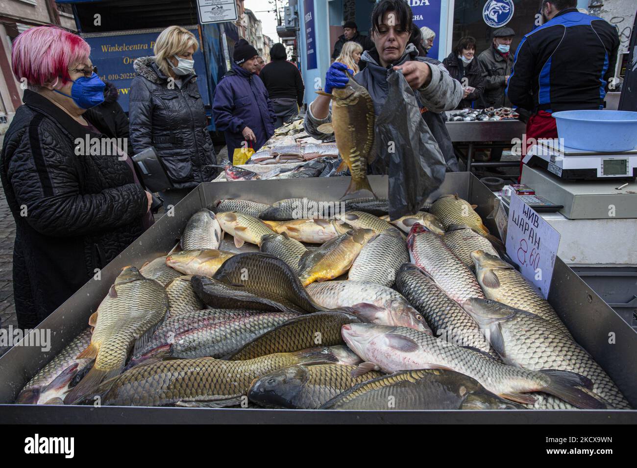 Les clients d'un marché à Sofia achètent du poisson le 05 décembre 2021, l'occasion du jour de Saint Nicolas le 06 décembre qui est vénéré comme le Saint patron des marins, voyageurs, marchands, et banquiers. L'élément obligatoire dans les rituels est la préparation des poissons dont le corps est recouvert de balances. (Photo de Hristo Vladev/NurPhoto) Banque D'Images