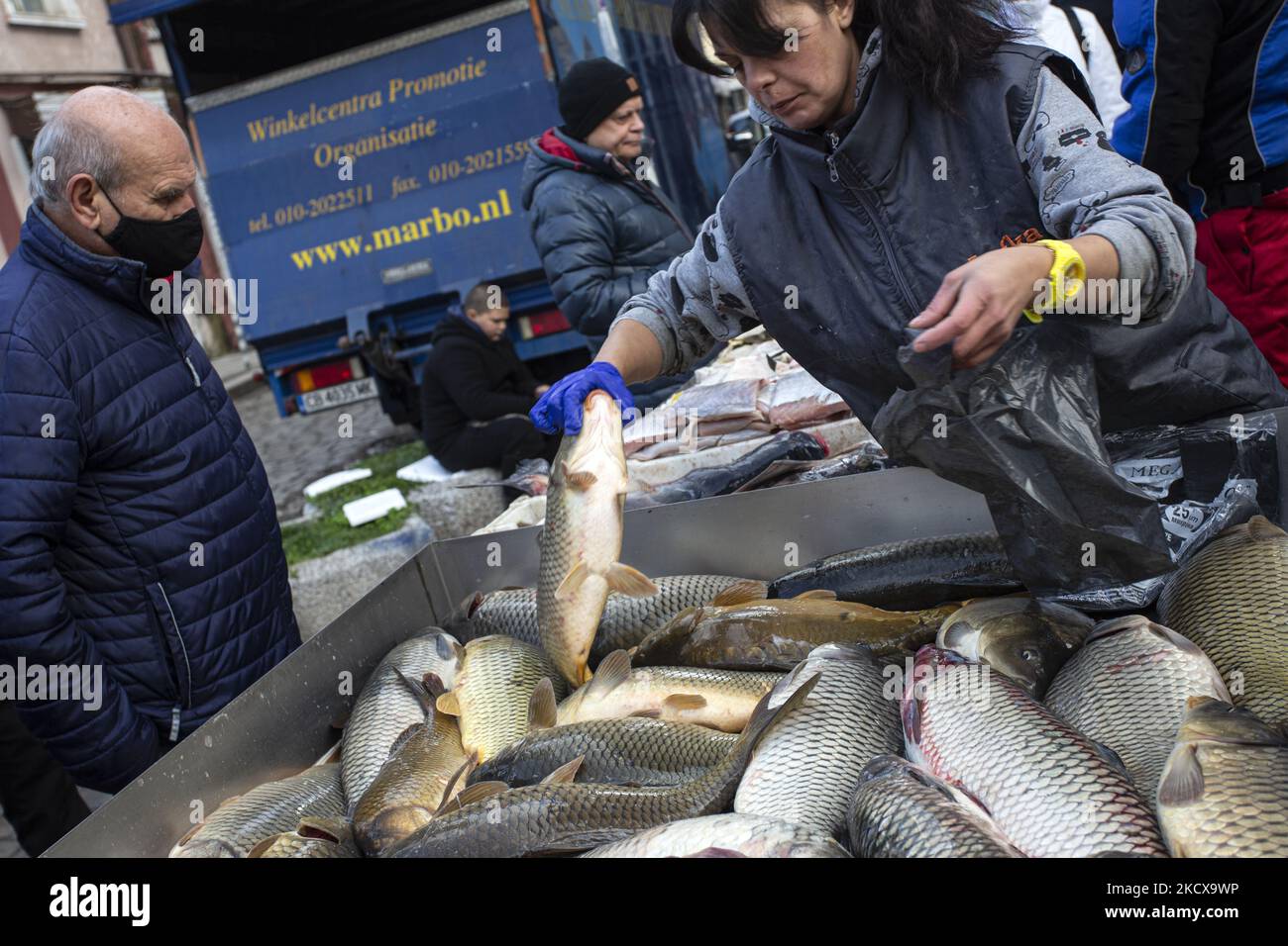 Les clients d'un marché à Sofia achètent du poisson le 05 décembre 2021, l'occasion du jour de Saint Nicolas le 06 décembre qui est vénéré comme le Saint patron des marins, voyageurs, marchands, et banquiers. L'élément obligatoire dans les rituels est la préparation des poissons dont le corps est recouvert de balances. (Photo de Hristo Vladev/NurPhoto) Banque D'Images