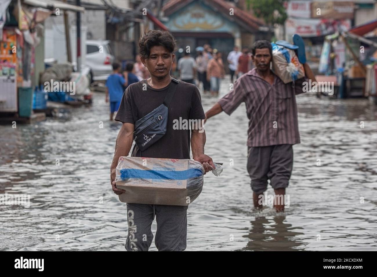 Les résidents se sont précipités dans une rue inondée par les vagues de marée dans la zone côtière de Jakarta, Muara Angke, le 7 décembre 2021. Les autorités locales ont prédit que des marées et des vents violents frapperont la région de la baie de Jakarta et le nord de W. Java du 6 au 9 décembre, ce qui provoquerait l'immersion de la zone côtière de la capitale et endommagera les maisons. Les inondations causées par le débordement d'eau de mer ont submergé 15 unités de quartier dans le nord de Jakarta et l'ouest de Jakarta. (Photo par Afriadi Hikmal/NurPhoto) Banque D'Images