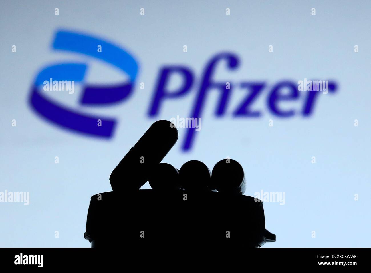 Les pilules de médicaments sont vues avec le logo de Pfizer en arrière-plan dans cette illustration photo prise à Cracovie, Pologne sur 14 décembre 2021. (Photo de Jakub Porzycki/NurPhoto) Banque D'Images