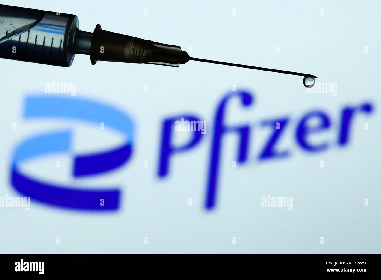 La seringue médicale est visible avec le logo Pfizer affiché en arrière-plan dans cette illustration photo prise à Cracovie, Pologne sur 14 décembre 2021. (Photo de Jakub Porzycki/NurPhoto) Banque D'Images