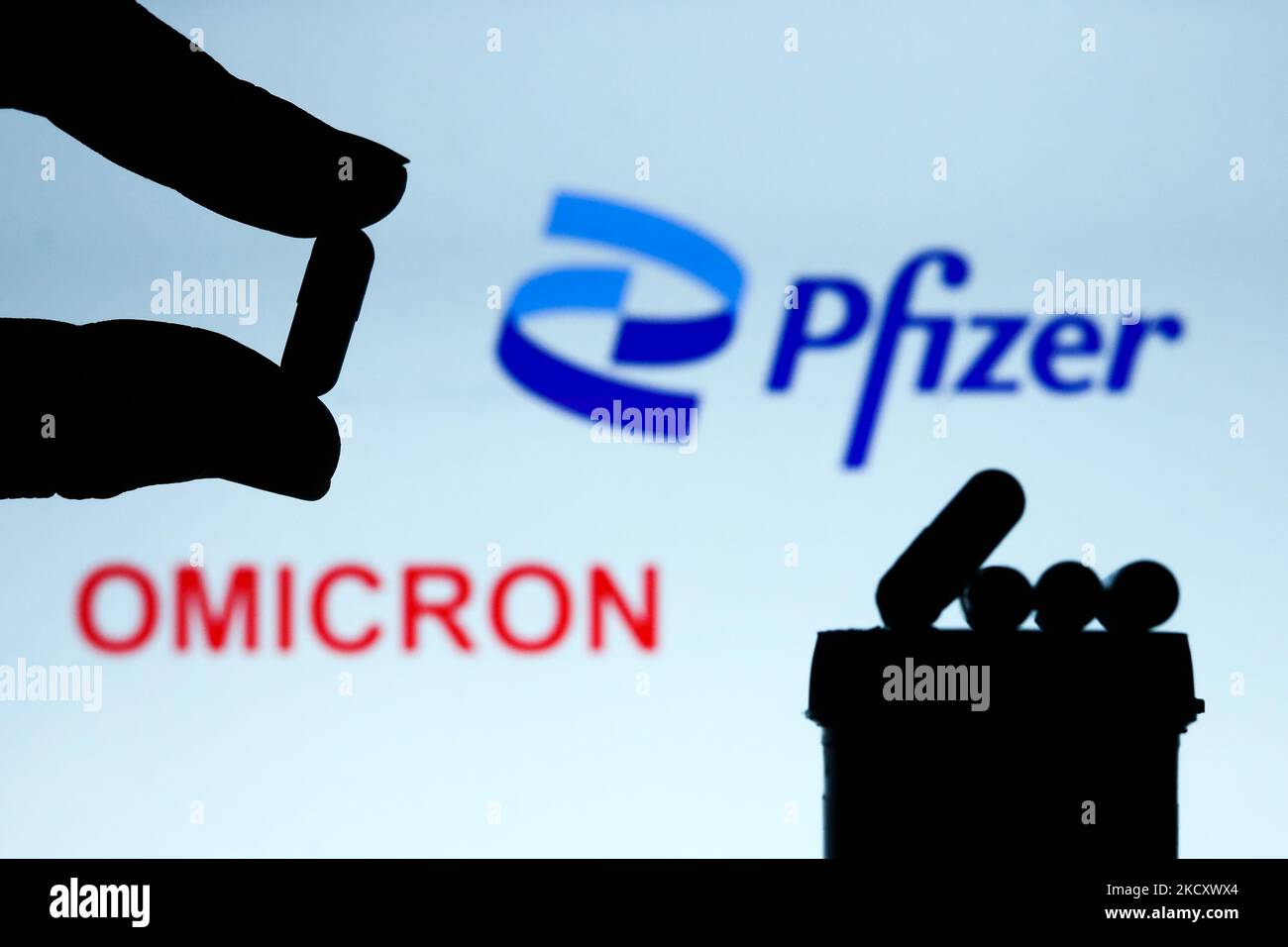 Les pilules de médicaments sont vues avec le logo Pfizer et le signe 'omicron' affiché en arrière-plan dans cette illustration photo prise à Cracovie, Pologne sur 14 décembre 2021. (Photo de Jakub Porzycki/NurPhoto) Banque D'Images