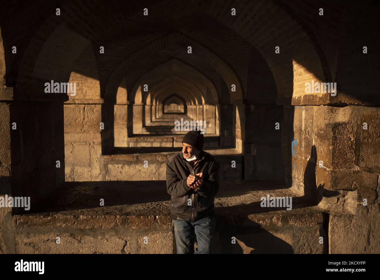 Un iranien s'accroche alors qu'il se trouve sur une fondation du pont historique de Khaju, sur la rivière sèche de la Rud de Zayandeh, dans la ville d'Isfahan, à 450 km (281 miles) au sud de Téhéran-14 décembre 2021. Zayandeh Rud est l'une des principales attractions touristiques d'Ispahan, qui a complètement séché, aussi les ponts historiques sur la rivière peuvent être endommagés en raison de l'affaissement du lit de la rivière Zayandeh Rud si la sécheresse continue. (Photo de Morteza Nikoubazl/NurPhoto) Banque D'Images
