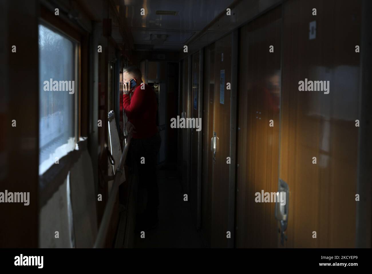 Un homme parle au téléphone dans une voiture de Lisichansk à Uzhgorod à la gare de Kupyansk. Région de Kharkiv, Ukraine orientale, Dimanche, 26 décembre 2021. Le train relie l'est à l'ouest de l'Ukraine. (Photo de Danil Shamkin/NurPhoto) Banque D'Images