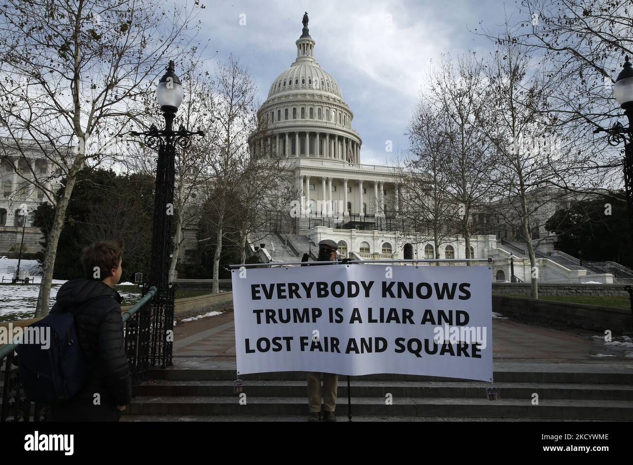 Un manifestant anti-Trump dissipe une bannière près du Capitole des États-Unis lors d'une journée de commémoration et d'action à l'occasion de l'anniversaire du « rassemblement Halte au vol » et de la tempête du Capitole des États-Unis, à 6 janvier 2022, à Washington D.C., États-Unis. Des vigiles publiques ont eu lieu à DC et dans tout le pays en souvenir du rassemblement pour l’anti-ratification de la victoire du Collège électoral du président Joe Biden sur l’ancien président Donald Trump. Le président Biden ainsi que les législateurs ont prononcé des remarques et tenu un moment de silence à la Chambre des communes pour les personnes perdues lors de la tempête du Capitole Banque D'Images