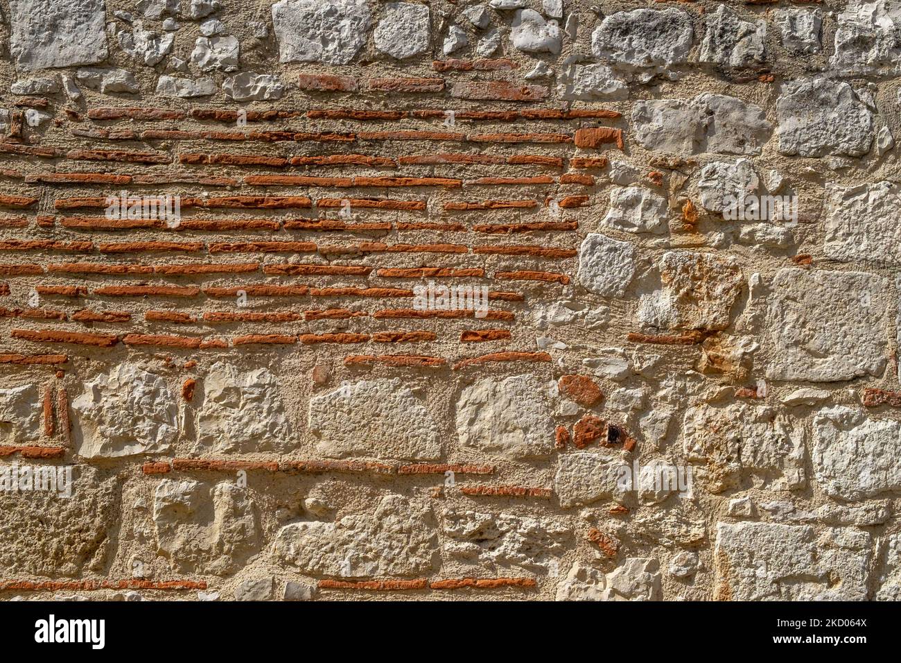 Un vieux mur de pierre et de tuile réparé et reconstruit surface texture arrière-plan Banque D'Images