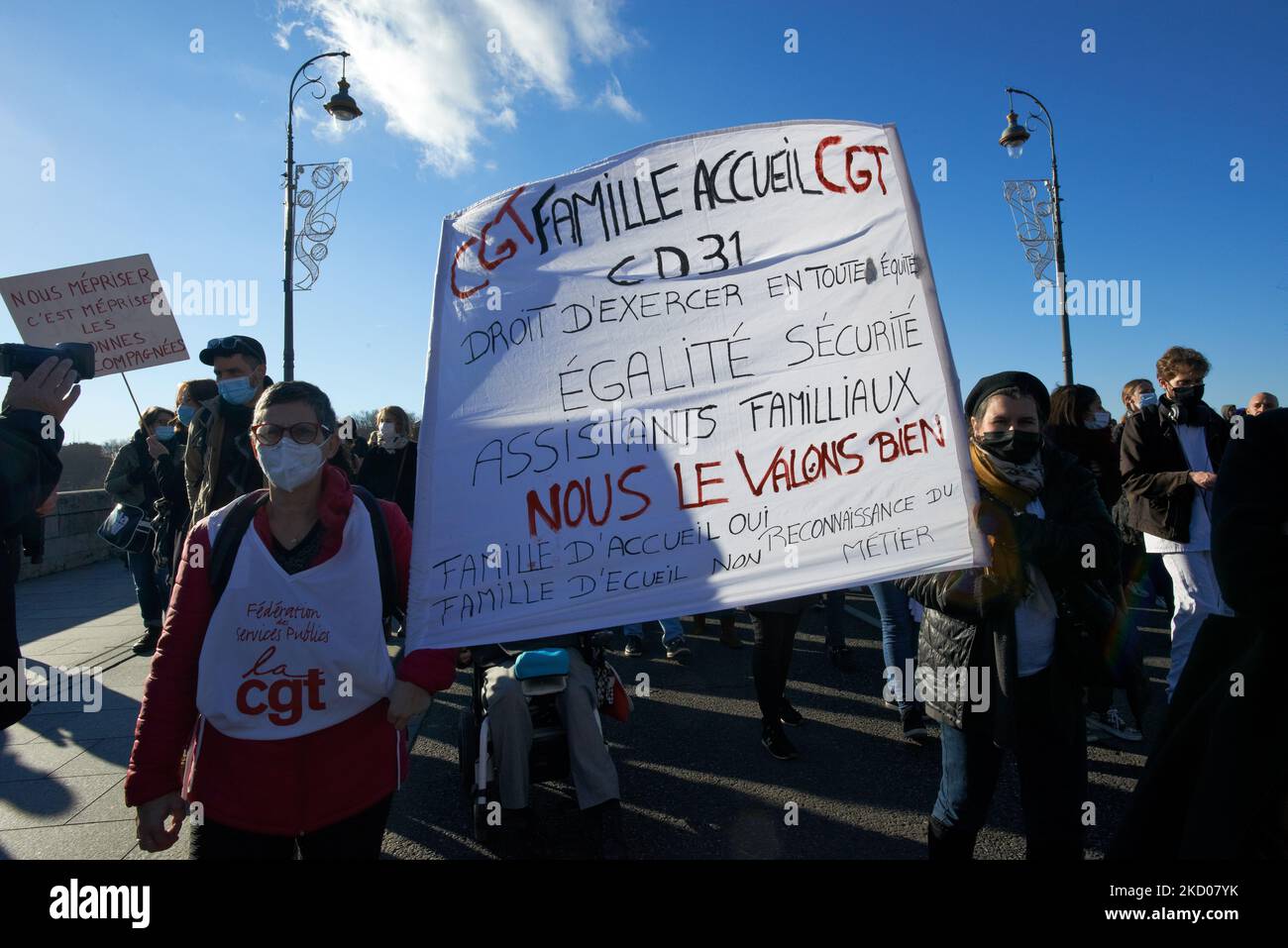 Deux manifestants ont une bannière portant la mention « famille d'accueil, droit à l'exercice dans l'équitéDoctors, infirmières, auxiliaires infirmiers et personnes ordinaires ont protesté contre le manque de moyens pour les hôpitaux publics car le nombre de lits est encore réduit. Le gouvernement Macron a coupé 5,700 lits dans les hôpitaux publics seulement en 2021. Les agents de santé de l'hôpital pour enfants de Toulouse (qui fait partie de l'hôpital universitaire de Purpan) sont en grève car certaines infirmières quittent le service et d'autres pensent au suicide en raison de mauvaises conditions de travail. Ils protestent également car chaque partie des services de santé publique en France souffre d'un manque Banque D'Images