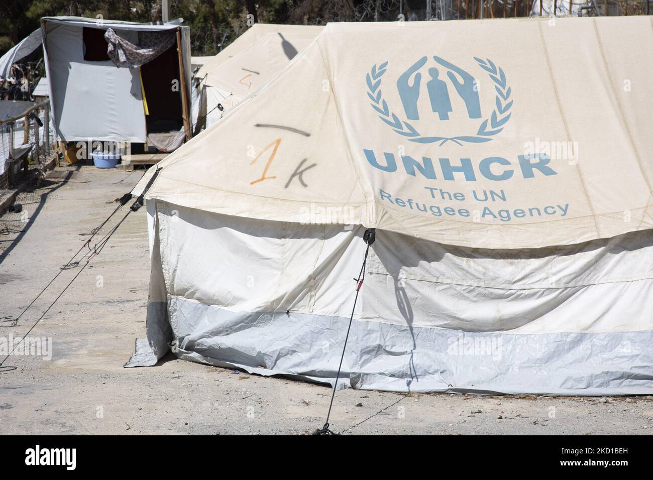 Tentes blanches dans le camp officiel avec le logo de l'Agence des Nations Unies pour les réfugiés. L'ancien camp officiel de réfugiés - migrants entouré d'une clôture barbelée sur l'île Vathy de Samos et le camp de fortune voisin avec des tentes faites à la main et certains du HCR qui est situé juste à côté des maisons de la ville de Vathi, comme vu déserté. Le camp a été vidé et les gens ont été déplacés ou déplacés avec l'escorte de police vers le nouveau camp et quelques très peu de maisons. Une fois que cette installation a accueilli à son pic 7500 demandeurs d'asile dans les installations officielles mais aussi le camp de fortune dans la forêt qui a été surnommé le Jun Banque D'Images