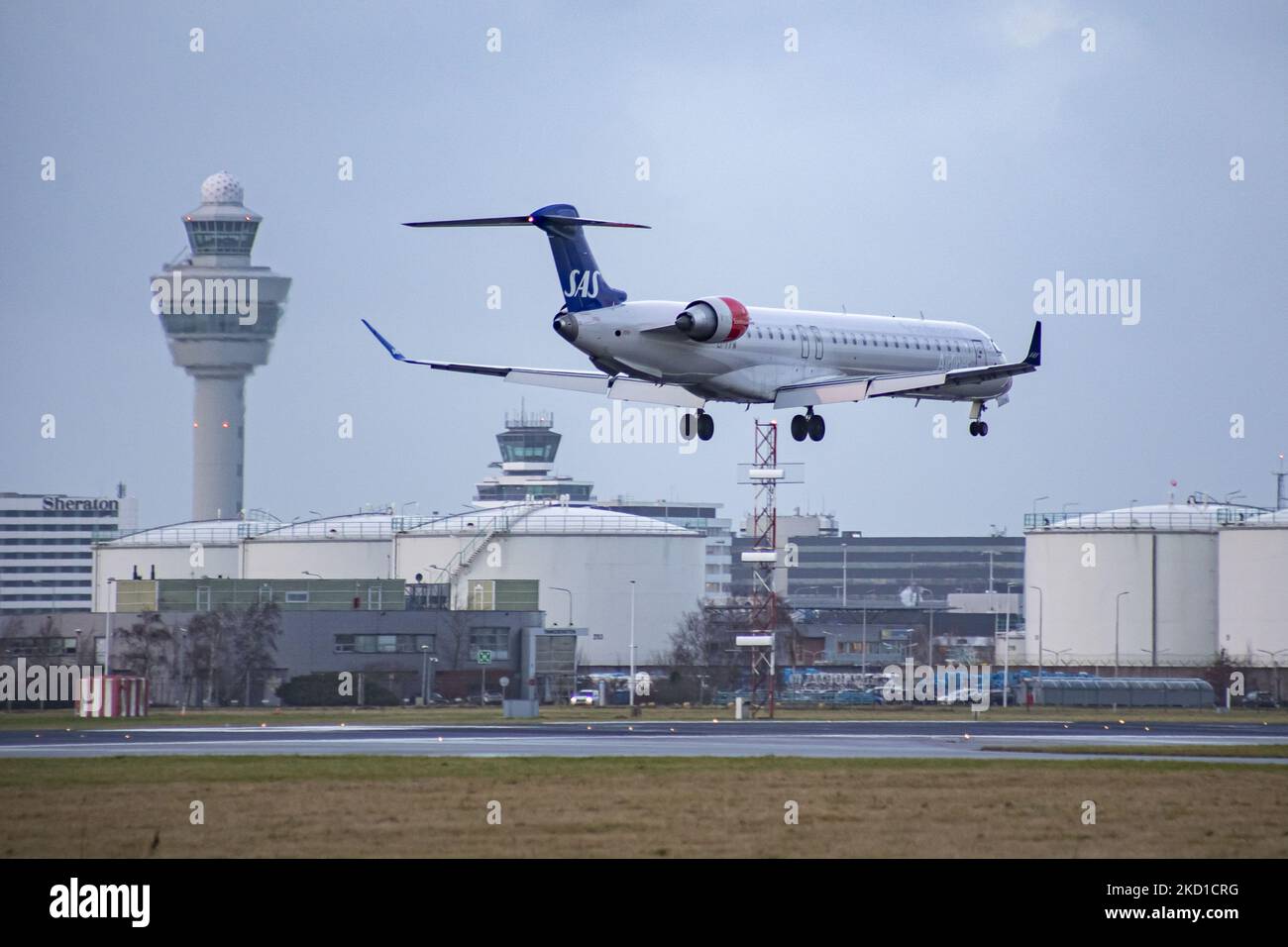 SAS Scandinavian Airlines Bombardier Mitsubishi CRJ-900 tel qu'il a été vu voler sur l'approche finale pour l'atterrissage à l'aéroport d'Amsterdam Schiphol AMS EHAM dans une soirée nuageux devant le terminal de l'aéroport et la tour de contrôle. L'avion régional à corps étroit a l'enregistrement EI-FPV et le nom Trud Viking. SAS est le porte-drapeau du Danemark, de la Norvège et de la Suède. Le nom est une abréviation de Scandinavian Airlines System. La compagnie aérienne compte 180 appareils et est membre du groupe d'aviation Star Alliance. L'industrie de l'aviation et le trafic de passagers sont en phase avec la Covid-19 co Banque D'Images