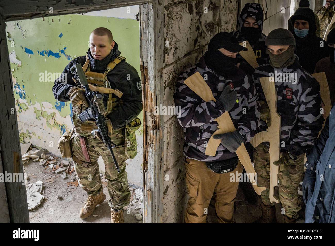 Un membre du bataillon Azov, parti, avec quelques volontaires civils pour les Brigades de défense territoriale de Kiev avec des fusils d'entraînement en bois lors d'un exercice militaire dans la banlieue de la ville. Après l'accumulation massive de l'armée russe à la frontière avec l'Ukraine, et le risque d'une invasion, les principales villes d'Ukraine ont créé des brigades civiles de défense avec une formation militaire. (Photo de Celestino Arce/NurPhoto) Banque D'Images