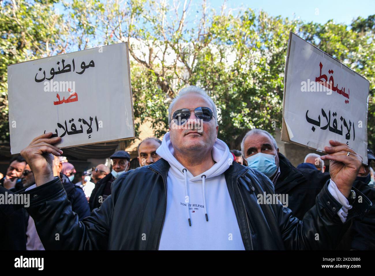 Un homme soulève une plaque qui lit en arabe, en bas avec le coup, et un autre, qui lit en arabe, citoyens contre le coup, lors d'une manifestation tenue à l'initiative de l'Association des juges tunisiens (AMT) à l'extérieur du bâtiment du Tribunal de première instance (Également appelé le Palais de justice) à Tunis, en Tunisie, sur 10 février 2022, pour protester contre la décision du président Kais Saied de dissoudre le Conseil judiciaire suprême du comté ainsi que contre la fermeture de son siège par les autorités tunisiennes. Les manifestants ont également appelé à l'indépendance du pouvoir judiciaire et de la justice Banque D'Images