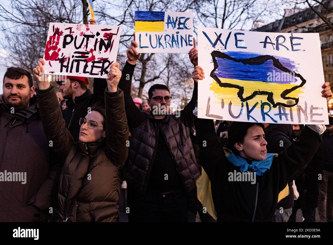 Des manifestants brandient des drapeaux ukrainiens autour de la statue de la République lors d'une manifestation organisée par l'Union des Ukrainiens en France et d'autres associations sur la place de la République à Paris, au 24 février 2022, en réaction à l'invasion de l'Ukraine par l'armée russe de Vladimir Poutine ce matin-là. (Photo de Samuel Boivin/NurPhoto) Banque D'Images