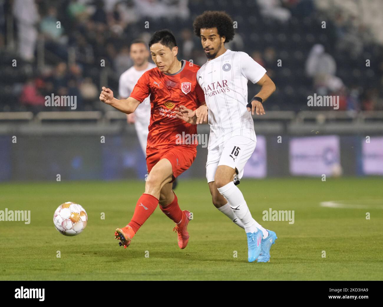 Akram Afif (15) d'Al Sadd et Nam Tae-hee (19) d'Al Duhail se disputent la possession lors du trophée de la Ligue des étoiles du QNB après le match de la Ligue des étoiles du QNB entre Al Sadd et Al Duhail au stade Jassim Bin Hamad à Doha, au Qatar, le 25 février 2022. (Photo de Simon Holmes/NurPhoto) Banque D'Images