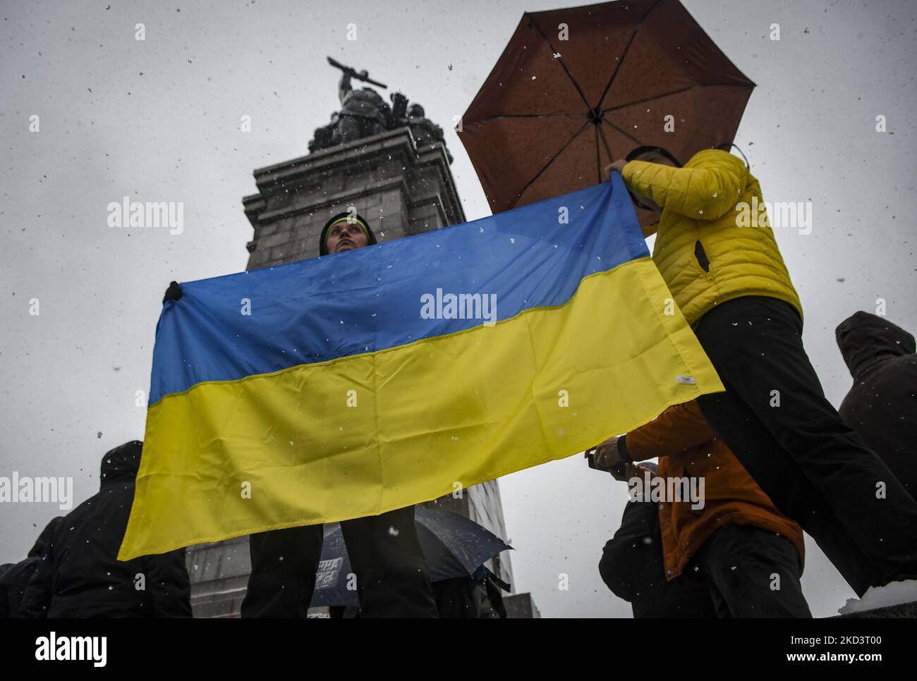 Les manifestants arborent le drapeau de l'Ukraine après avoir peint par pulvérisation le monument des soldats russes de la Seconde Guerre mondiale au mémorial de l'Armée rouge dans le centre-ville de Sofia, Bulgarie, le 27 février 2022 (photo de Georgi Paleykov/NurPhoto) Banque D'Images