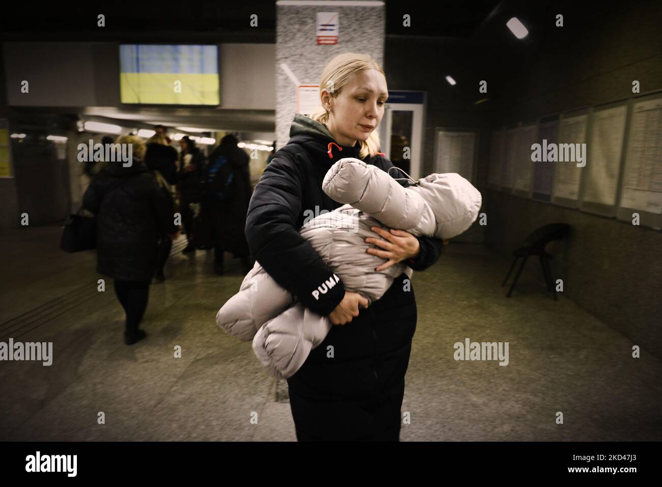 Une femme porte un jeune enfant après un train transportant quelque 350 réfugiés de Kiev, en Ukraine, à la gare de Varsovie est à Varsovie, en Pologne, le 04 mars 2022. Chaque jour, plusieurs milliers de réfugiés arrivent dans les gares de Varsovie, fuyant la violence après l'invasion de la Russie. Près d'un million de personnes ont fui l'Ukraine après l'invasion russe et environ 700 000 d'entre elles ont fui en Pologne. Grâce à un certain nombre d'initiatives privées et publiques et aux efforts des municipalités locales, des réfugiés d'Ukraine ont été reçus à bras ouverts et bénéficient d'un abri, de nourriture gratuite et de transports gratuits Banque D'Images