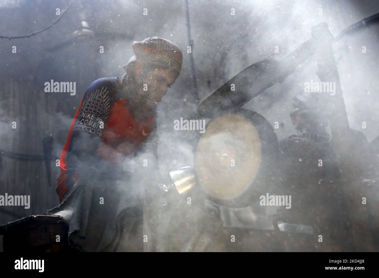 L'ouvrier travaille dans un environnement de poussière à l'intérieur d'une usine d'ustensile tandis que des rayons solaires entrent par le toit à Dhaka, au Bangladesh, sur 08 mars 2022. (Photo de Kazi Salahuddin Razu/NurPhoto) Banque D'Images