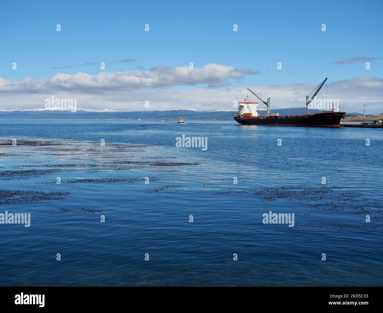 Le bateau à conteneurs a été amarré dans le port d'Ushuaia, en Argentine, sous un ciel bleu nuageux Banque D'Images