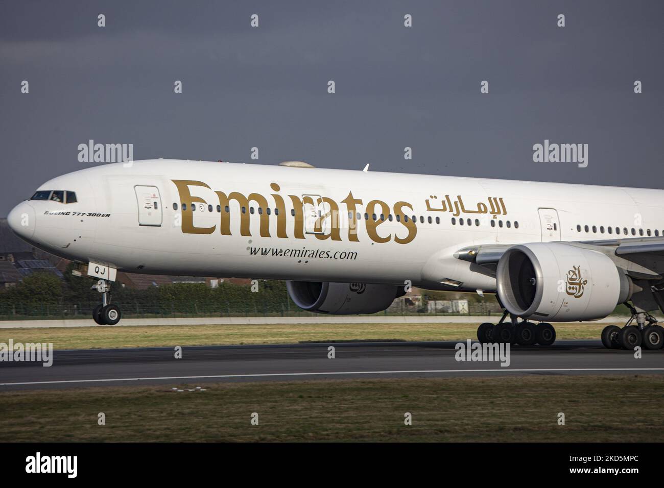 Emirates Boeing 777 comme vu voler et atterrir sur la piste avec la tour de contrôle et les nuages en arrière-plan. Emirates B777 avion comme vu sur l'approche finale vol, atterrissage et le roulement au sol à la capitale belge, l'aéroport de Bruxelles Zaventem BRU. Le Boeing Boeing 777-31HER, un avion de transport de passagers à gros corps moderne et avancé, est immatriculé A6-EQJ et est équipé de 2x GE90 moteurs à réaction. L'avion arrive à la ville européenne en provenance de Dubai DXB, Émirats Arabes Unis. Emirates est la plus grande compagnie aérienne et l'une des deux, porte-drapeau des Émirats arabes Unis. L'industrie de l'aviation et le trafic de passagers Banque D'Images