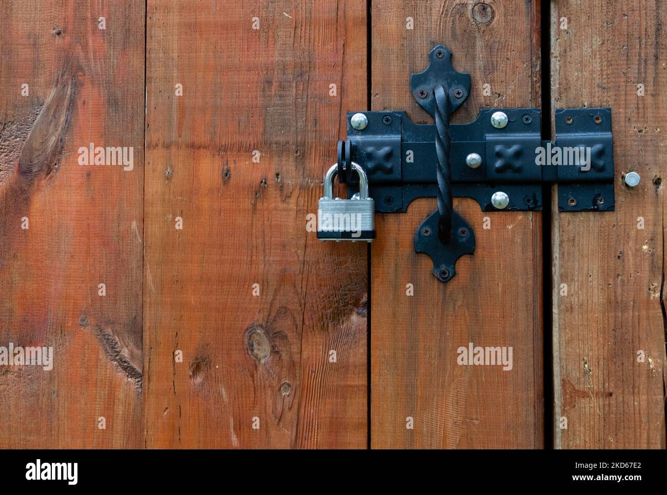 Cadenas en métal fermé, gros plan sur la porte en bois du loquet Banque D'Images