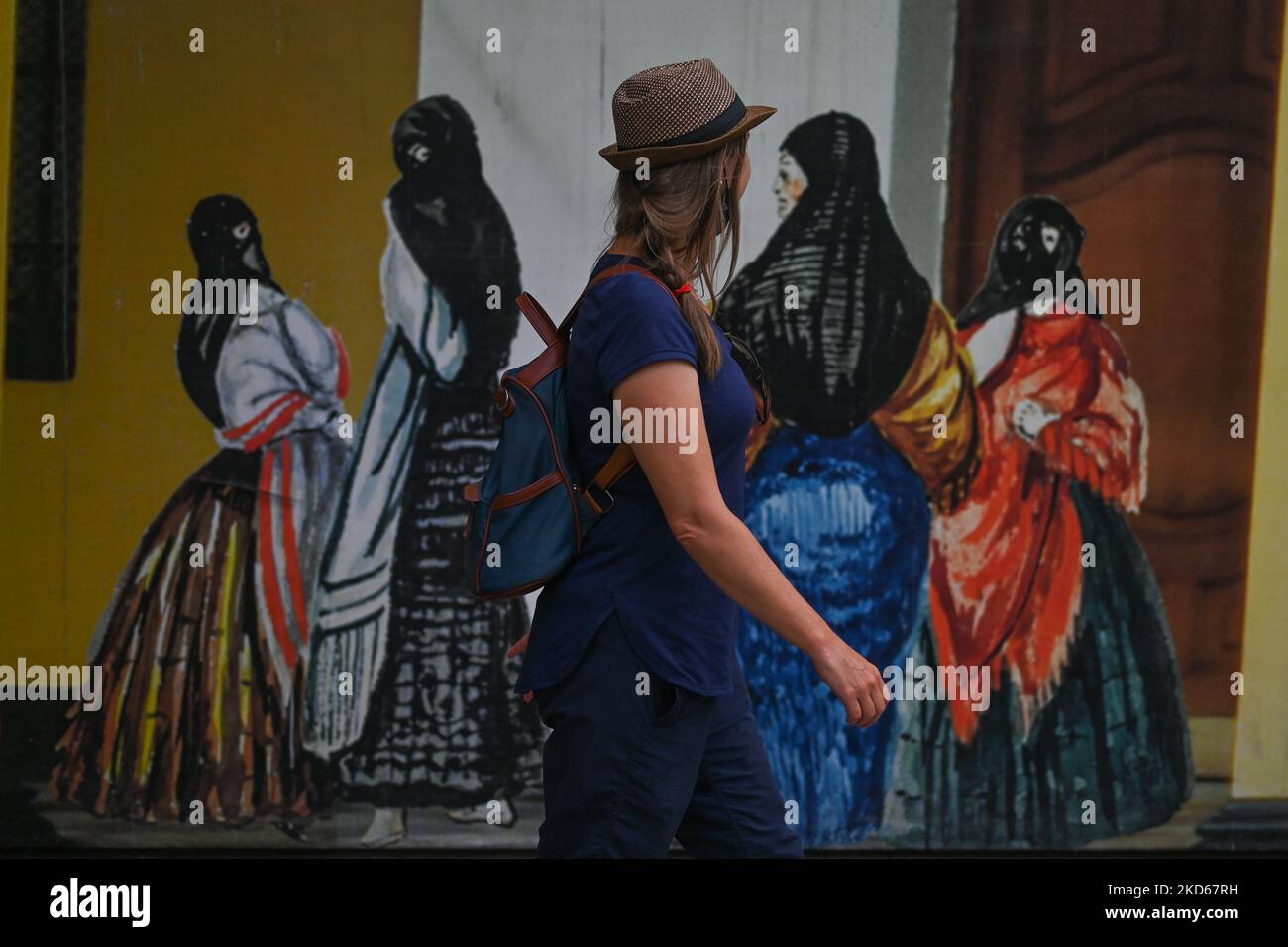 Une femme passe devant un panneau d'affichage avec des images de Tapadas, les femmes voilées symbolisant la liberté au Pérou. Le dimanche 27 mars 2022, à Lima, au Pérou. (Photo par Artur Widak/NurPhoto) Banque D'Images