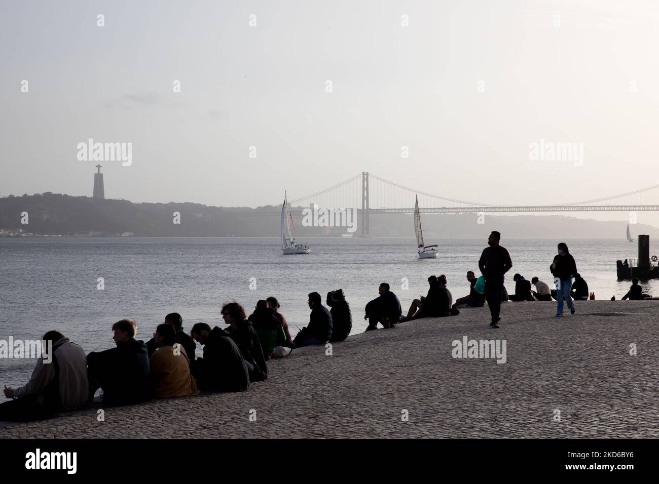 Les gens assistent au coucher du soleil sur la rive du Tage à Lisbonne, au Portugal, sur 29 mars 2022. (Photo de Manuel Romano/NurPhoto) Banque D'Images