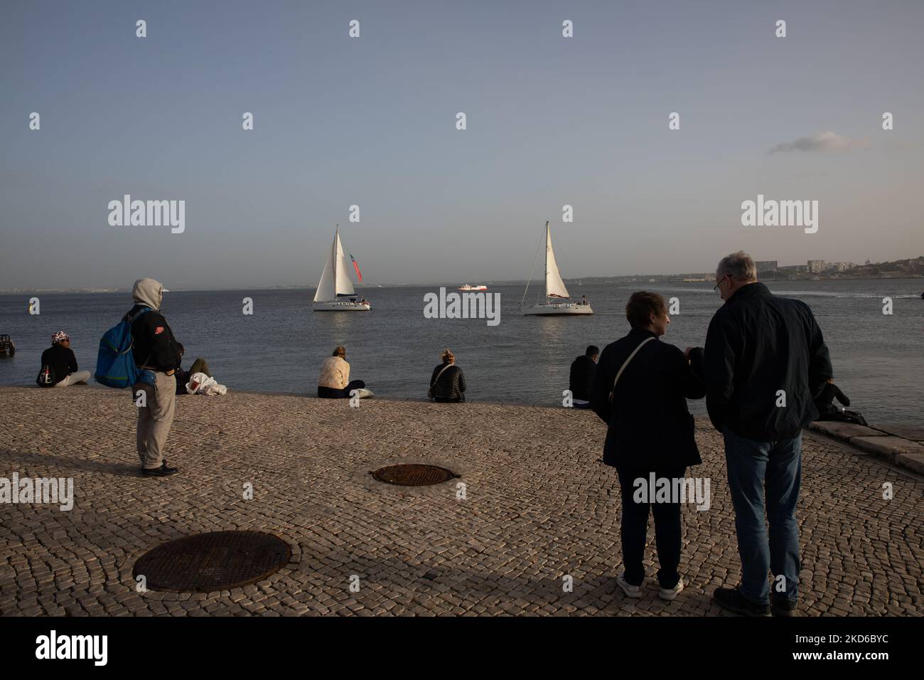 Les gens assistent au coucher du soleil sur la rive du Tage à Lisbonne, au Portugal, sur 29 mars 2022. (Photo de Manuel Romano/NurPhoto) Banque D'Images
