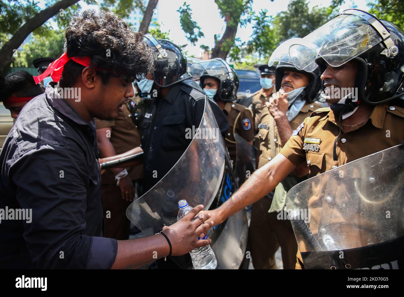 Un policier a remis une bouteille d'eau à un étudiant lors d'une manifestation au ministère de la Santé de Colombo au sujet de questions d'éducation et de la crise économique croissante de l'île sur 6 avril 2022. (Photo par Pradeep Dambarage/NurPhoto) Banque D'Images