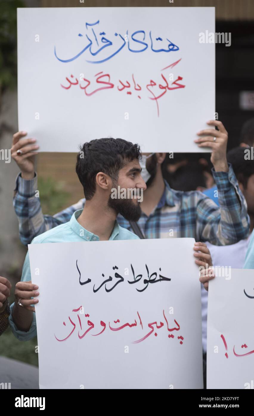 Deux hommes iraniens tiennent des pancartes avec des textes perses lus, insultant le Coran devrait être condamné (Top), et nos lignes rouges sont le Coran et messager, lors d'une réunion de protestation devant l'ambassade de Suède dans le nord de Téhéran pour condamner l'incendie du Coran en Suède, sur 18 avril 2022. (Photo de Morteza Nikoubazl/NurPhoto) Banque D'Images