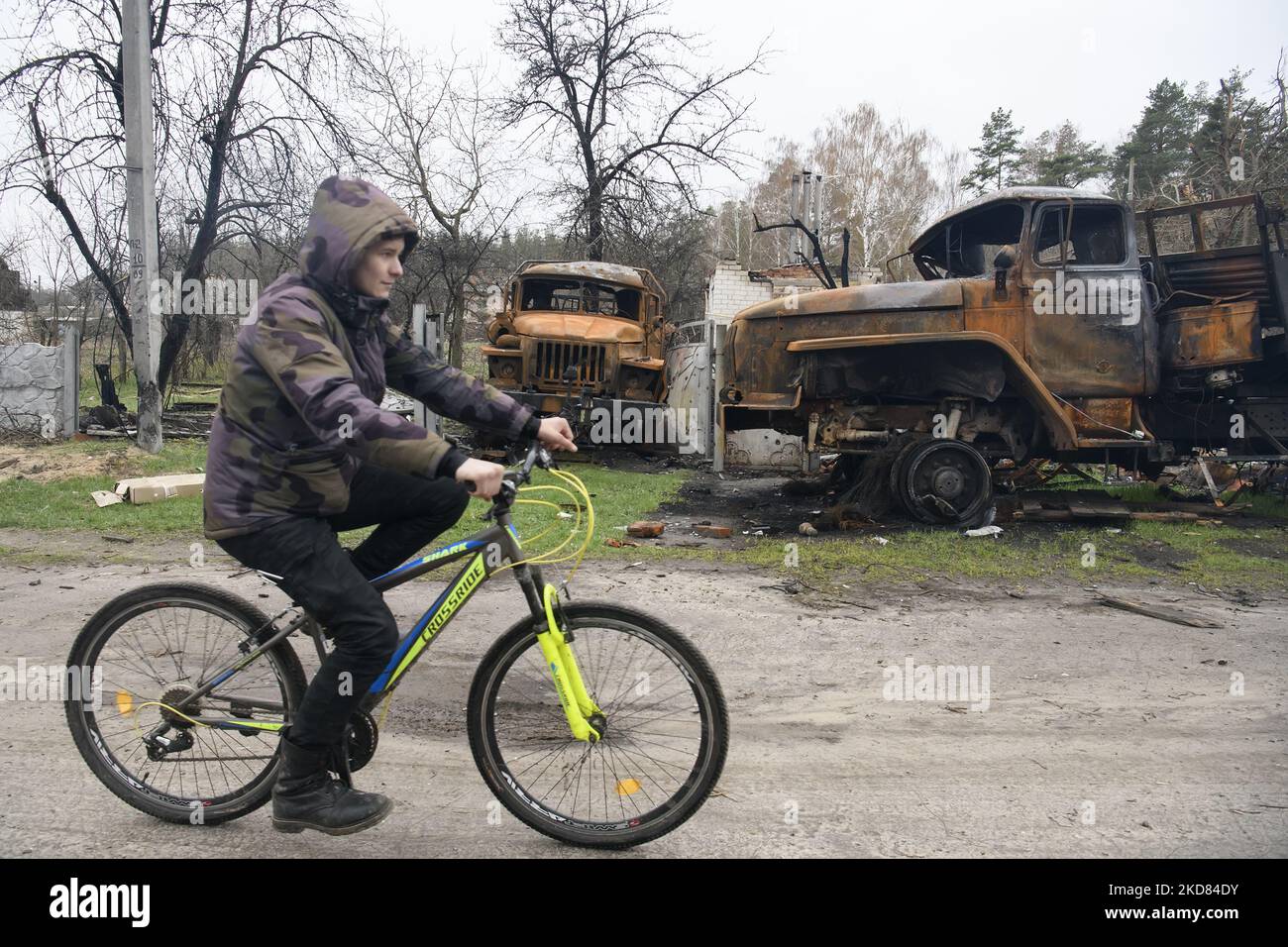 Homme local à vélo près de machines militaires russes détruites dans le village de Yahidne, région de Chernihiv, Ukraine, 20 avril 2022 (photo de Maxym Marusenko/NurPhoto) Banque D'Images