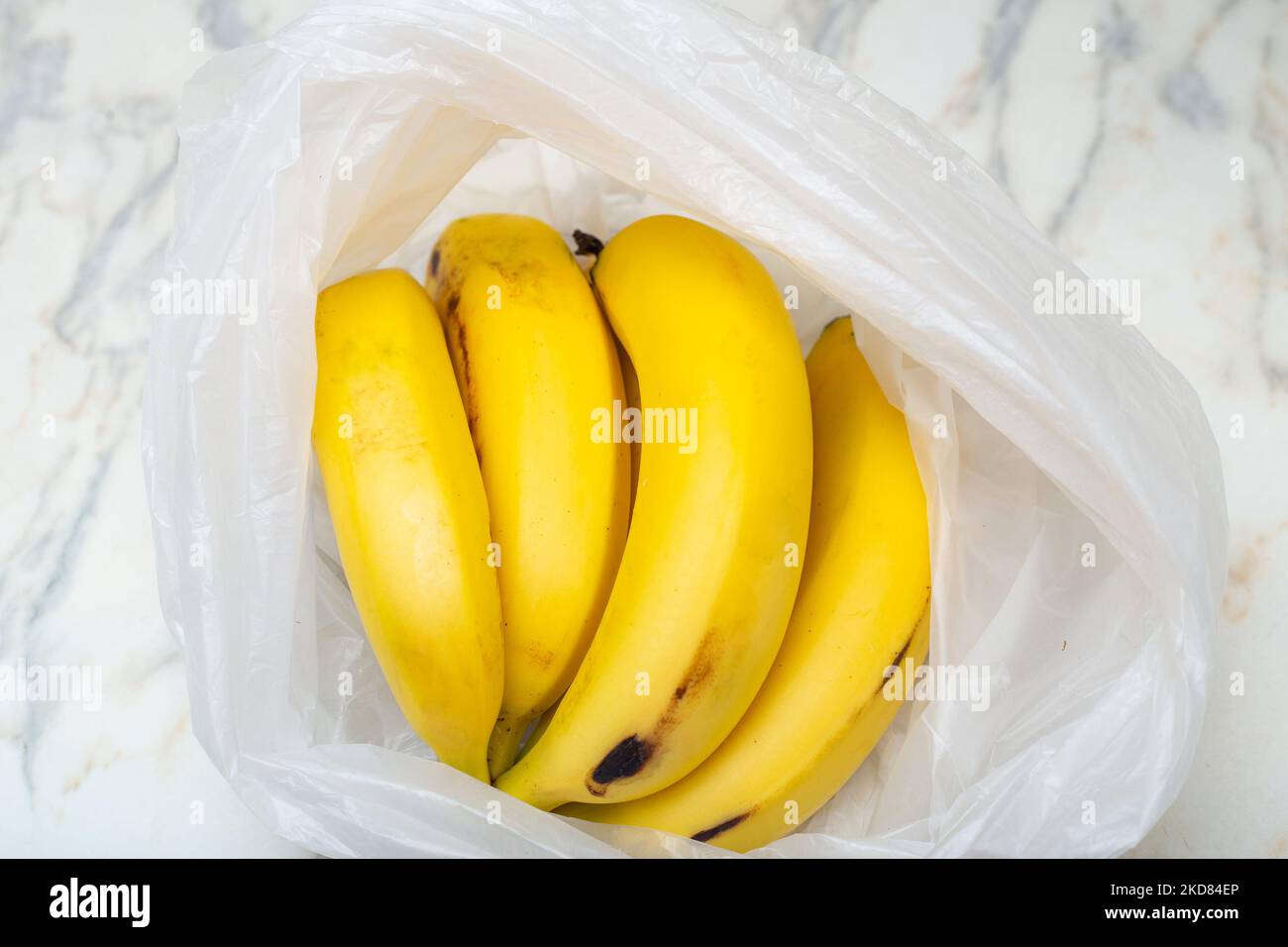 Goias, Brésil – 05 novembre 2022 : un bouquet de bananes dans un sac en plastique sur la table. Banque D'Images