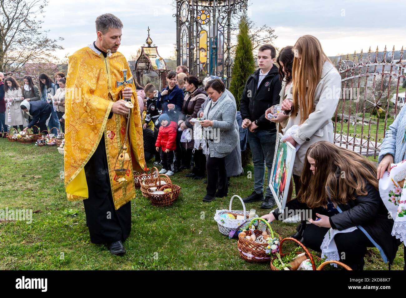 Les fidèles ukrainiens assistent à la cérémonie de bénédiction traditionnelle du panier de nourriture du samedi Saint dans l'église grecque-catholique de Nadyby, oblast de Lviv, Ukraine sur 23 avril 2022. Alors que la Fédération de Russie envahissait l'Ukraine il y a près de deux mois, le conflit a forcé plus de 10 millions d'Ukrainiens à fuir les zones de guerre, tant à l'intérieur qu'à l'extérieur. L'oblast de Lviv accueille de nombreux réfugiés internes. Le village de Nadyby et son église catholique grecque sont devenus un refuge pour des dizaines de réfugiés de Kharkiv, Donesk et Zaporizhzhia Oblast. Comme les fidèles ukrainiens se réunissent pour les célébrations orthodoxes de Pâques, les chrétiens locaux et le RE Banque D'Images