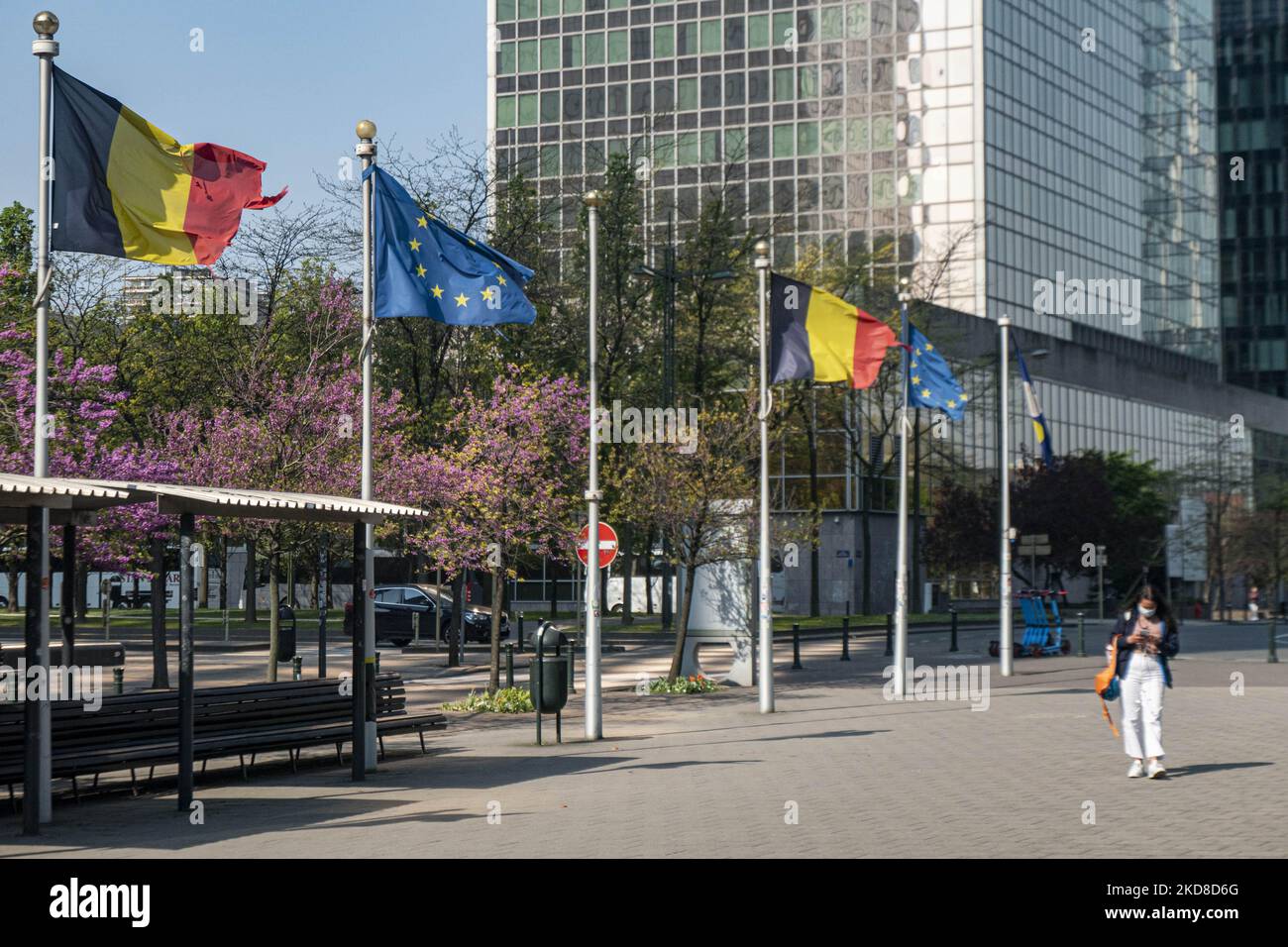 Les gens marchent devant les mâts de drapeau avec des drapeaux de