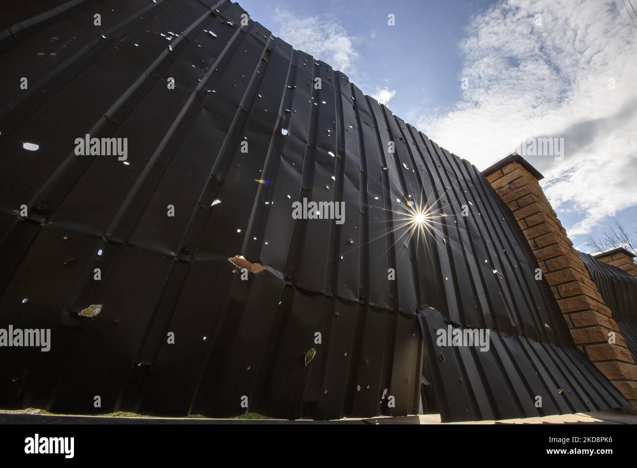 La lumière du soleil brille à travers un trou dans une clôture de fragments d'artillerie près d'une maison résidentielle, détruite pendant l'invasion de l'Ukraine par la Russie, à Moshchun, Ukraine 29 avril 2022 (photo de Maxym Marusenko/NurPhoto) Banque D'Images