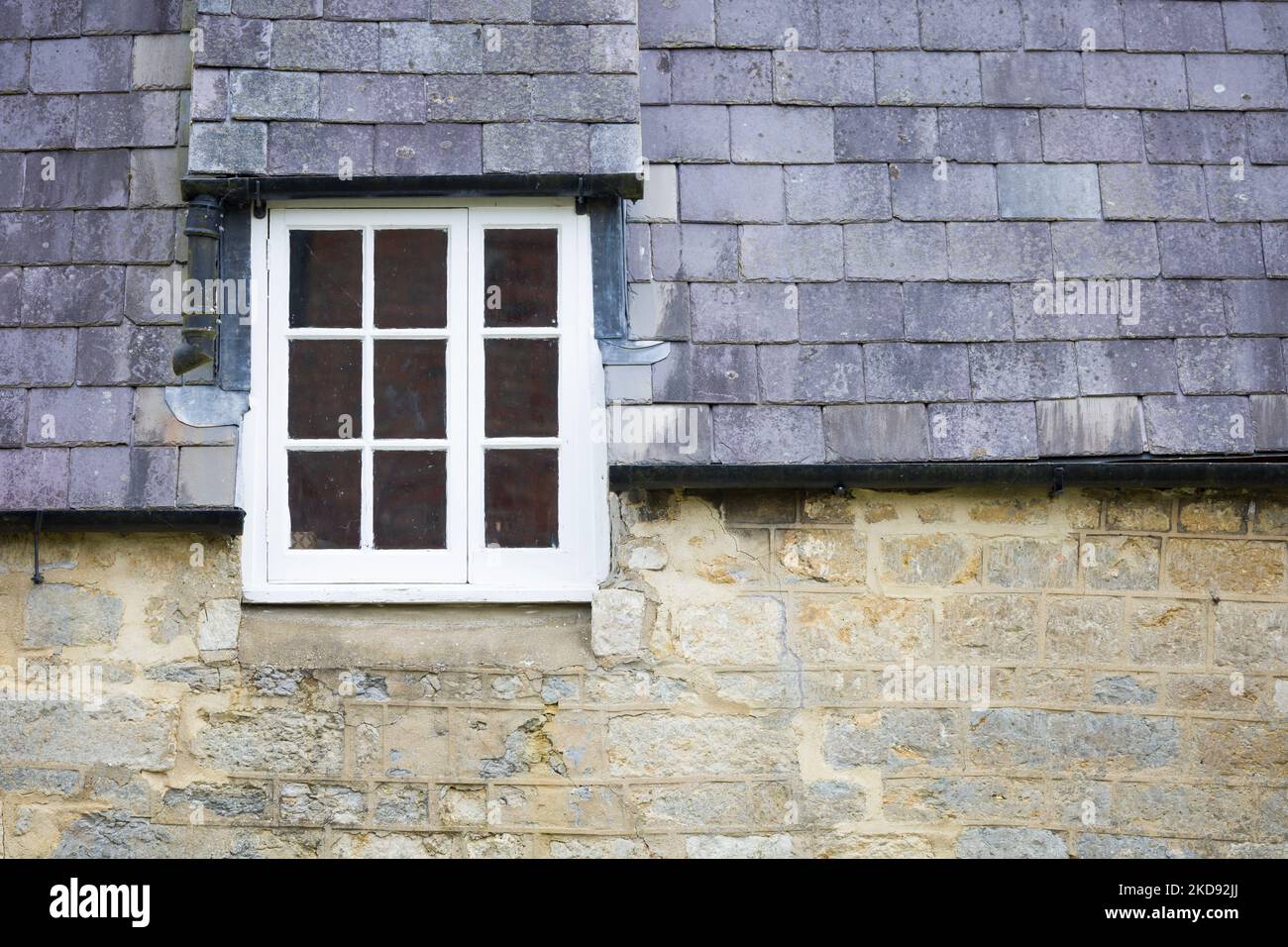 Détail du vieux cottage en Angleterre, Royaume-Uni, avec des murs en pierre et une fenêtre de dortoirs dans un toit en ardoise Banque D'Images