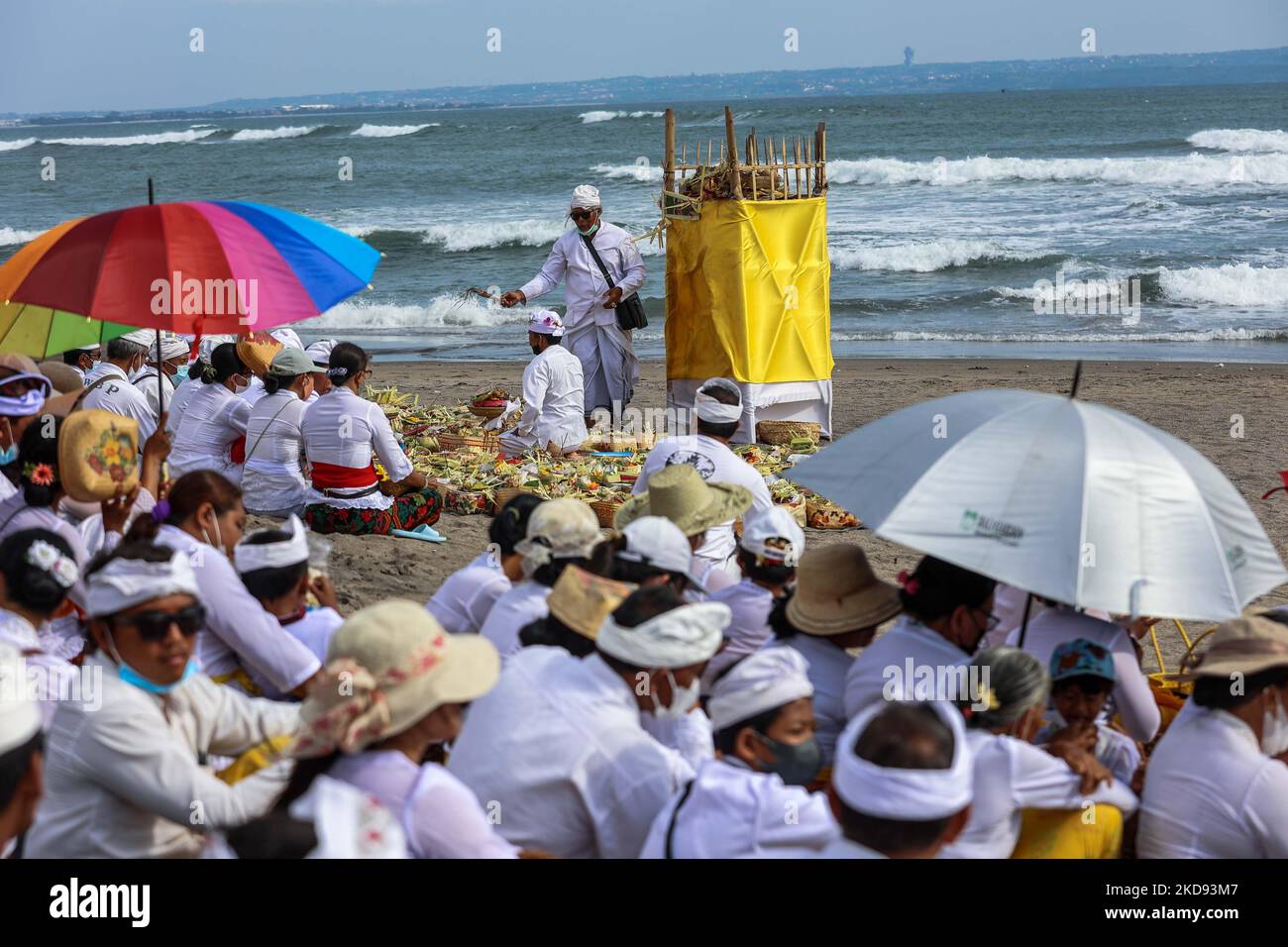 Les dévotés hindous balinais se réunissent alors qu'ils effectuent des prières pendant le Melasti, une cérémonie de purification devant Nyepi à la plage de Canggu à Badung, Bali, Indonésie 28 février 2022. Les hindous balinais vêtus d'une tenue à dominante blanche transportaient des effigies sacrées de dieux et de déesses et des paraphernalia rituels de leurs temples de village à la plage pour effectuer une cérémonie de purification appelée le rituel de Melasti. Les Hindous balinais croient que le rituel de Melasti est un must devant le jour de Nyepi, le jour du silence, pour nettoyer l'âme et la nature, recharger le pouvoir surnaturel des temples objets sacrés an Banque D'Images