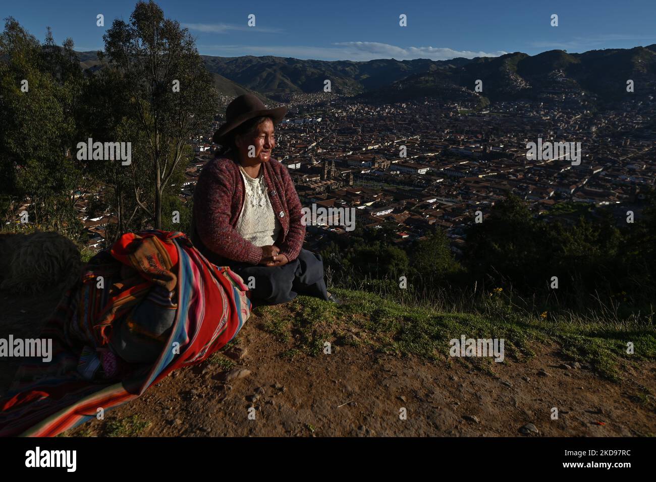 Une femme quechua habillée de façon traditionnelle se place près de la route avec le panorama de la ville de Cusco en arrière-plan, près de la statue du Christ. Le dimanche 17 avril 2022, à Cusco, Pérou. (Photo par Artur Widak/NurPhoto) Banque D'Images