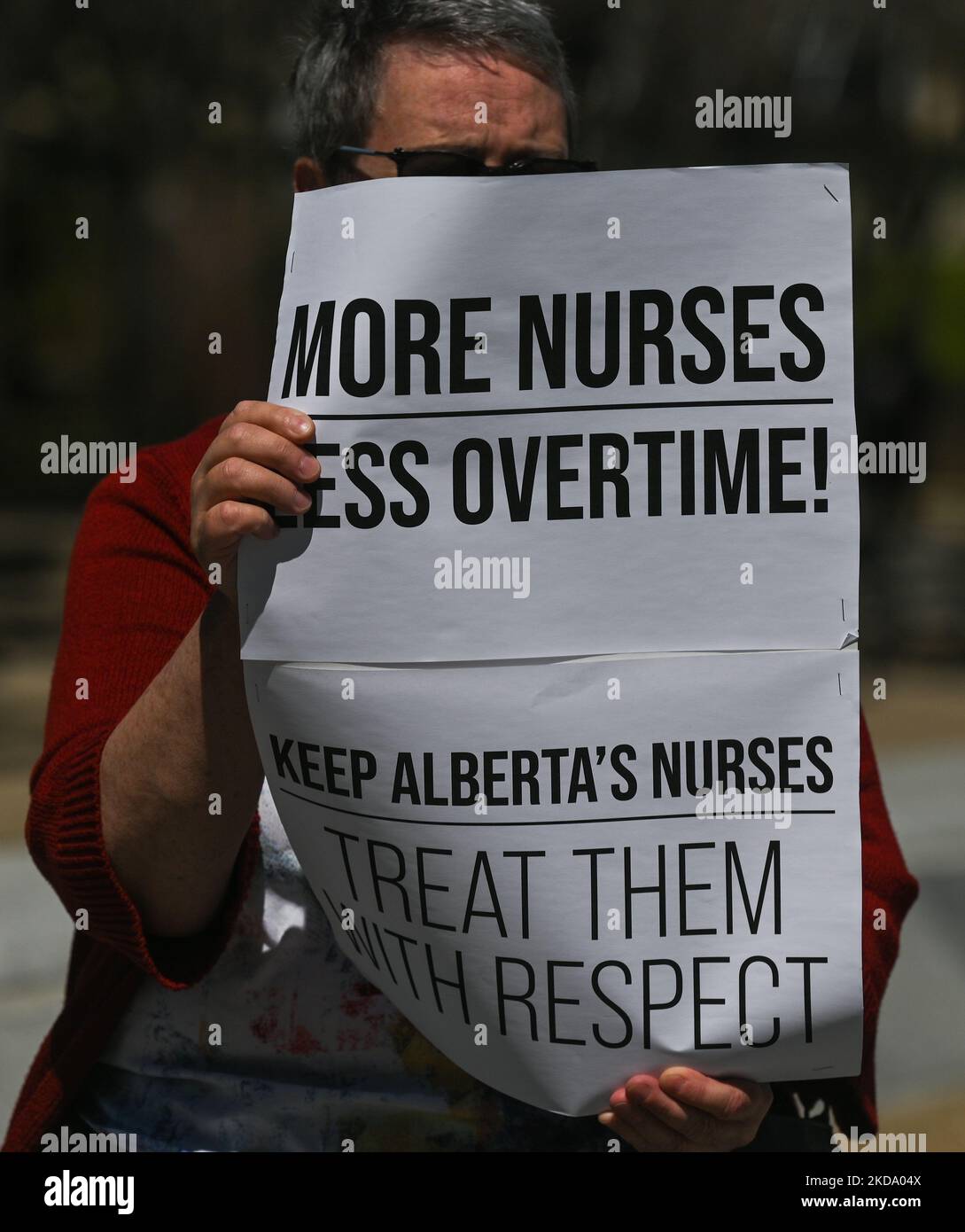 Un manifestant tient un écriteau avec les mots « plus d'infirmières moins d'heures supplémentaires! ». Les travailleurs de la santé, les activistes et leurs partisans ont protesté cet après-midi lors du rassemblement pour les soins de santé publics à l'Assemblée législative de l'Alberta, à Edmonton, contre le premier ministre Kenney et le gouvernement du PCU qui prennent des mesures pour privatiser les soins de santé. Le samedi 14 mai 2022, à Edmonton, Alberta, Canada. (Photo par Artur Widak/NurPhoto) Banque D'Images