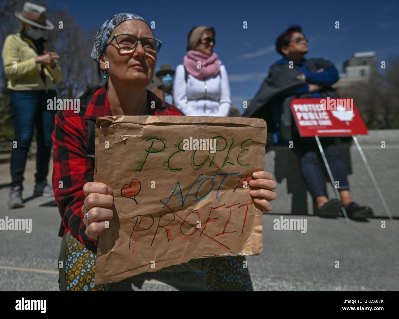 Un manifestant tient un écriteau avec les mots « People Not profit ». Les travailleurs de la santé, les activistes et leurs partisans ont protesté cet après-midi lors du rassemblement pour les soins de santé publics à l'Assemblée législative de l'Alberta, à Edmonton, contre le premier ministre Kenney et le gouvernement du PCU qui prennent des mesures pour privatiser les soins de santé. Le samedi 14 mai 2022, à Edmonton, Alberta, Canada. (Photo par Artur Widak/NurPhoto) Banque D'Images