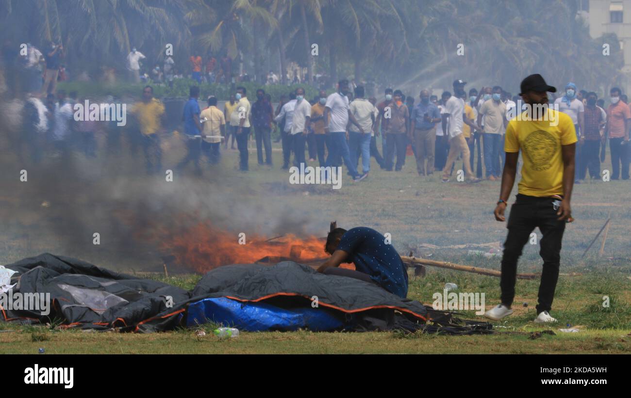 Un manifestant anti-gouvernement sri-lankais tente de récupérer ses effets de sa tente qui est en feu alors que les manifestants pro-gouvernement se penchent sur de nombreuses tentes à Gotagogama près du bureau du président Gotabaya Rajapaksa à Colombo, au Sri Lanka. 09 mai 2022 . (Photo de Thharaka Basnayaka/NurPhoto) Banque D'Images