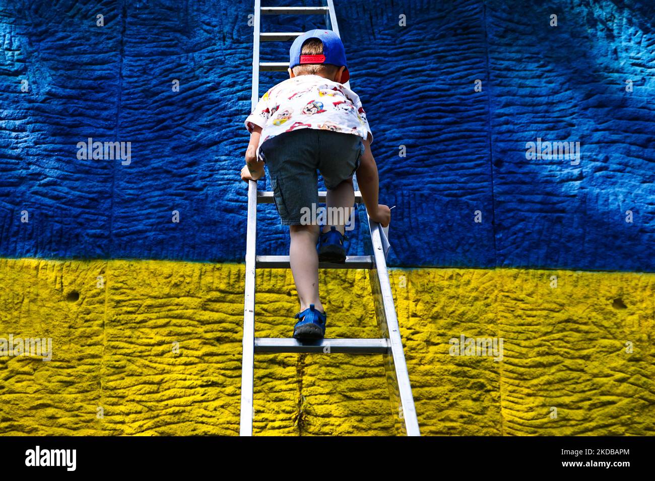 Un garçon ukrainien escalade une échelle tout en célébrant la Journée internationale de l'enfance lors d'un événement organisé sur le piédestal de l'ancien monument du maréchal soviétique Ivan Konev, repeint dans les couleurs du drapeau ukrainien après l'invasion russe en février. Cracovie, Pologne sur 1 juin 2022. (Photo de Beata Zawrzel/NurPhoto) Banque D'Images