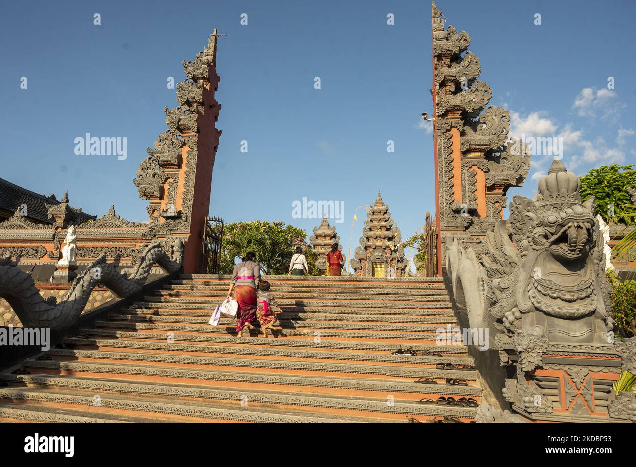 Une mère conduit son enfant à marcher dans la porte pour exécuter le rituel de prière du jour Galungan au Grand Temple Wanakerta Jagatnatha, ville de Palu, province centrale de Sulawesi, Indonésie sur 8 juin 2022. Le jour de Galungan est célébré le jour bouddhiste de Kliwon Dungulan comme le jour de la victoire du Dharma (Justice) contre Adharma (mal) qui est commémoré tous les 210 jours sur la base des calculs de Pawukon. Galungan peut être interprété comme une forme de silence sur la prospérité et le bien-être accordés par Dieu tout-puissant. Galungan est une échelle à une vie plus propre. (Photo de Basri Marzuki/NurPhoto) Banque D'Images