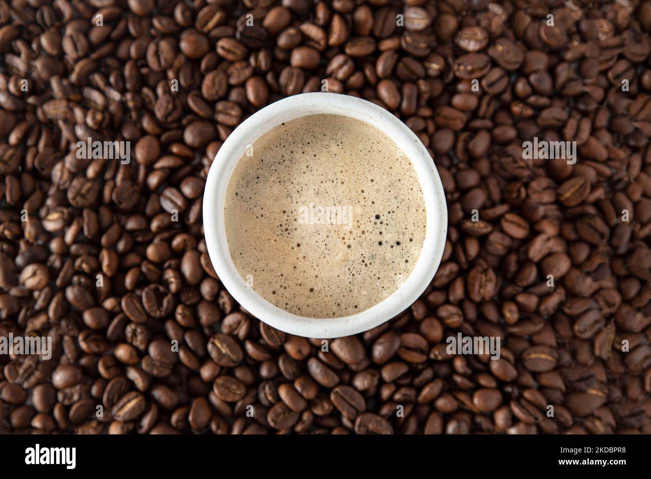 Une tasse de café sur une pile de grains de café Banque D'Images